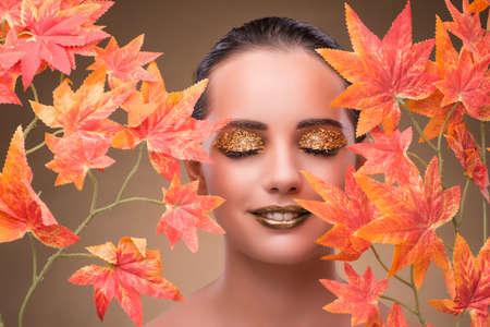Young woman with dry autumn leavesの写真素材