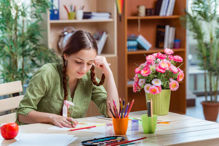 Young girl drawing pictures at homeの写真素材