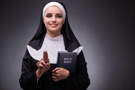 Religious nun in religion concept against dark backgroundの写真素材