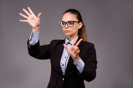Young woman businesswoman pressing virtual buttonsの写真素材