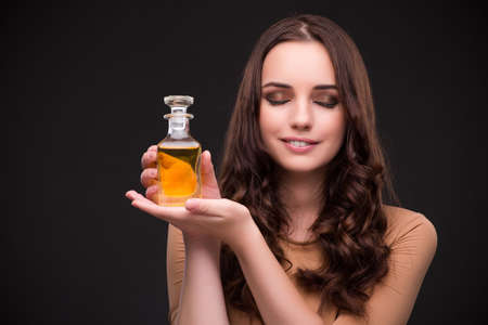 Young woman with bottle of perfume