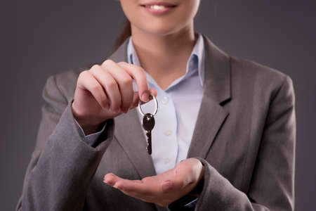 Woman holding keys in housing mortgage conceptの写真素材