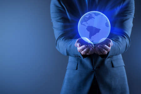 Businessman holding globe in global business conceptの写真素材