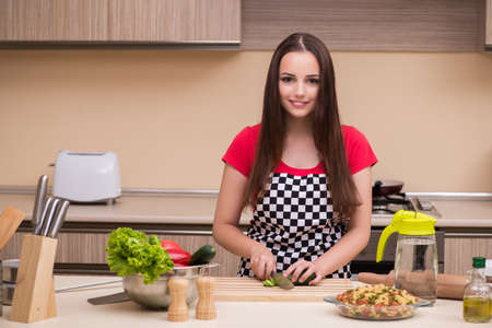 Young woman housewife working in the kitchen