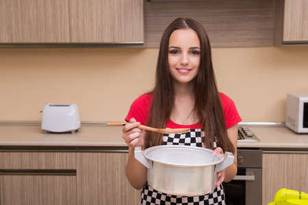 Young woman housewife working in the kitchenの写真素材