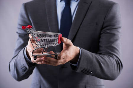Buisinessman holding shopping cart in online shopping conceptの写真素材