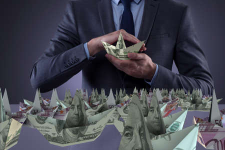 Businessman holding dollar paper boatsの写真素材