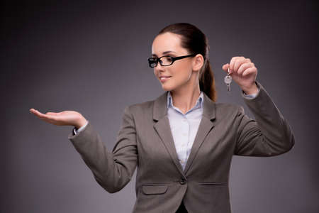 Woman holding keys in housing mortgage conceptの写真素材