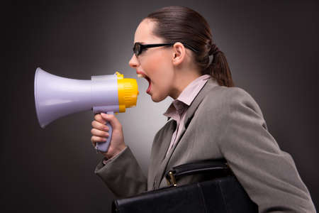Young businesswoman with loudspeaker in business conceptの写真素材