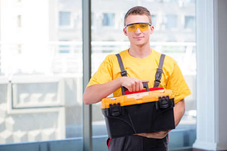 Young construction worker in yellow coverallsの写真素材