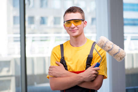 Young construction worker in yellow coverallsの写真素材