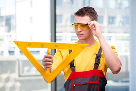 Young construction worker in yellow coveralls