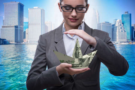 Businesswoman with dollar boats in business conceptの写真素材