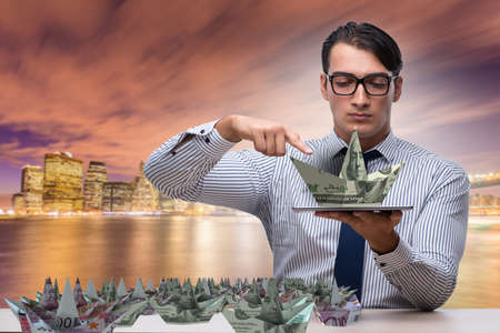 Businessman with dollar paper boatsの写真素材