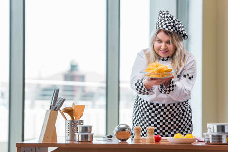 Woman cook working in the bright kitchenの写真素材
