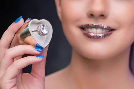 Young woman receiving proposal with diamond ring