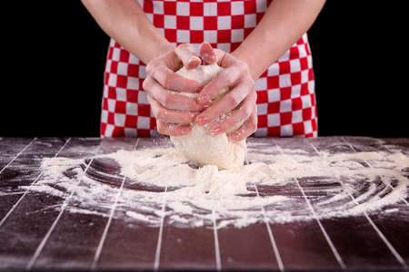 Cook preparing dough for baking in the kitchen