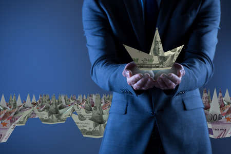 Businessman with dollar paper boatsの写真素材