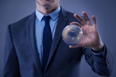 Businessman holding globe in global business conceptの写真素材
