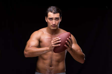 Ripped muscular man with american footballの写真素材
