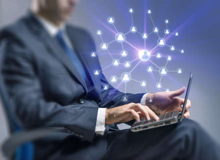 Young man with laptop in social network concept