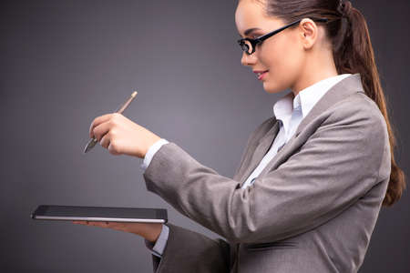 Businesswoman working on tablet computer in business conceptの写真素材