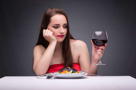 Beautiful woman eating alone with wineの写真素材