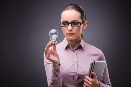 Businesswoman holding light bulb in creativity conceptの写真素材