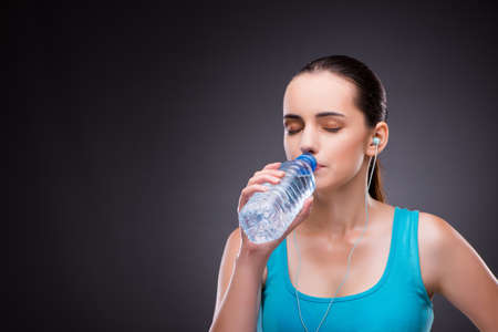 Woman doing sports with bottle of fresh water