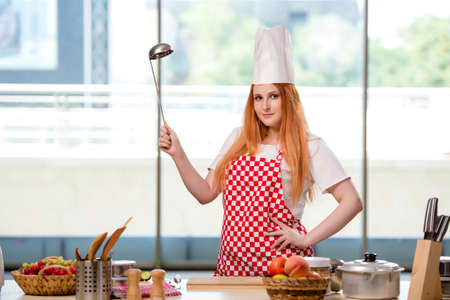 Redhead cook working in the kitchenの写真素材