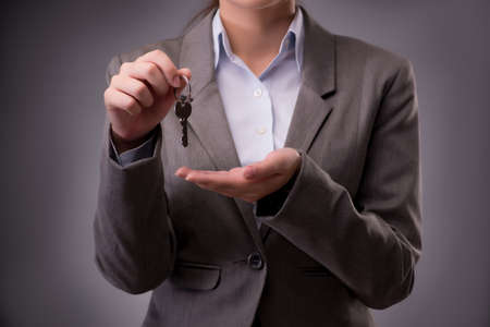 Woman holding keys in housing mortgage conceptの写真素材
