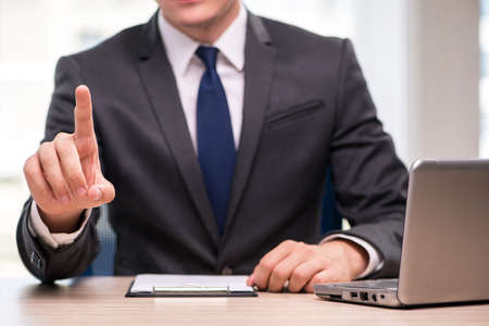 Young businessman pressing buttons in business concept