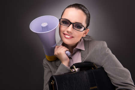 Young businesswoman with loudspeaker in business conceptの写真素材