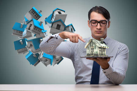 Young handsome businessman in mortgage conceptの写真素材