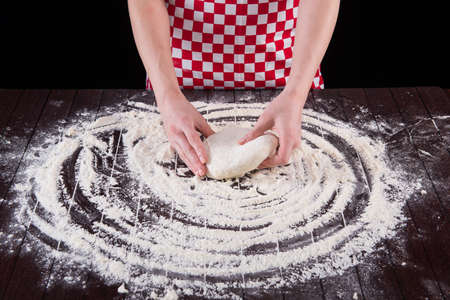 Cook preparing dough for baking in the kitchenの写真素材