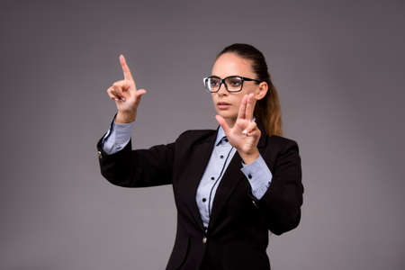 Young woman businesswoman pressing virtual buttonsの写真素材