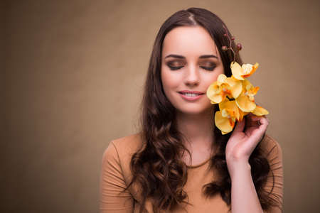 Beautiful woman with yellow orchid flowerの写真素材