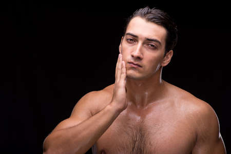 Man after taking shower on dark backgroundの写真素材