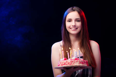 Young woman with birthday cake at party