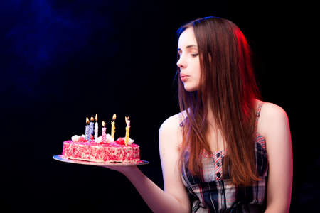 Young woman with birthday cake at partyの写真素材