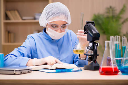 Lab chemist working with microscope and tubes