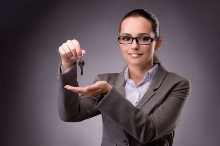 Woman holding keys in housing mortgage conceptの写真素材