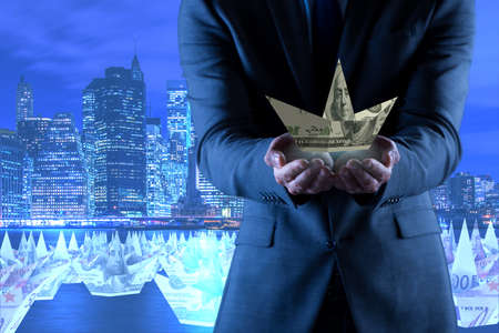 Businessman with dollar paper boatsの写真素材
