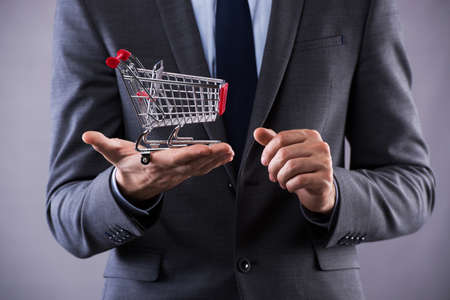Buisinessman holding shopping cart in online shopping conceptの写真素材