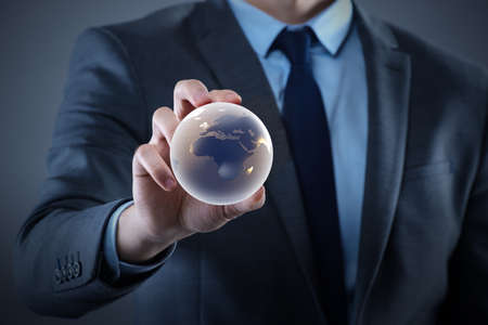 Businessman holding globe in global business conceptの写真素材