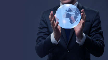 Businessman holding globe in global business conceptの写真素材