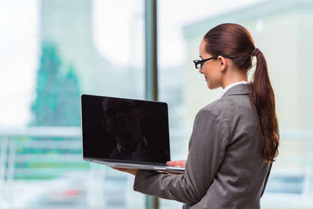 Businesswoman with laptop in business conceptの写真素材