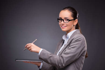 Businesswoman working on tablet computer in business conceptの写真素材