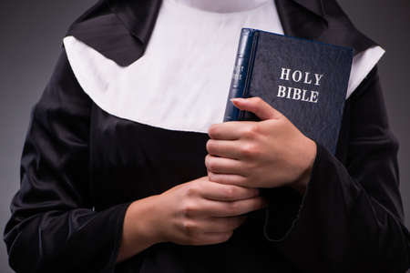 Religious nun in religion concept against dark backgroundの写真素材