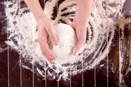 Cook preparing dough for baking in the kitchen